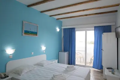 a bedroom with a white bed and a blue wall at Romantza Mare in Kallithea Rhodes