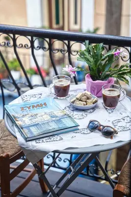 a table with two cups of coffee and a plate of cookies at Ilioni Apartment in Symi