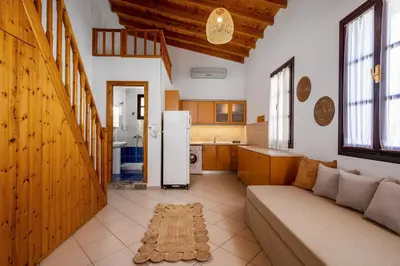 a living room with a couch and a kitchen at Ilioni Apartment in Symi