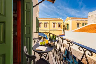 a balcony with a table with fruit on it at Lito Studio in Symi