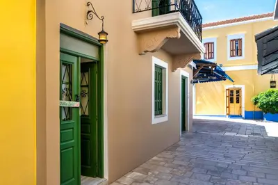 a building with a green door on a street at Lito Studio in Symi