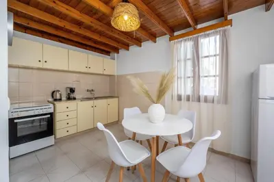 a kitchen with a white table and white chairs at Lito Studio in Symi