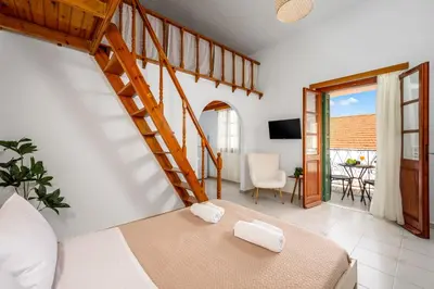 a bedroom with a bed and a spiral staircase at Lito Studio in Symi