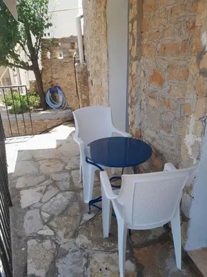a table and chairs sitting next to a stone wall at 