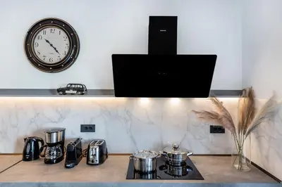 a clock on a wall above a counter with pots and pans at Rhodes Center Luxury Apartments #2 in Rhodes Town