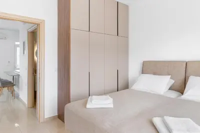 a white bedroom with a bed with two towels on it at Grande View Haraki in Haraki