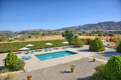 a large swimming pool with chairs and umbrellas at Grande View Haraki in Haraki