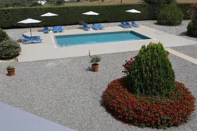 a swimming pool in a yard with flowers and bushes at Grande View Haraki in Haraki