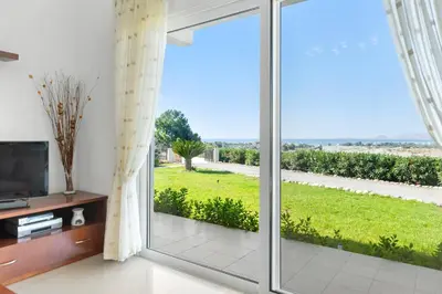 a living room with a large sliding glass door at Grande View Haraki in Haraki
