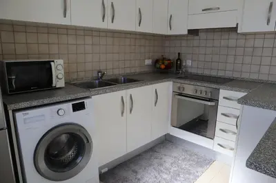 a kitchen with a sink and a washing machine at Grande View Haraki in Haraki