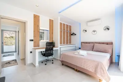 a bedroom with a bed and a desk and a chair at M&B Luxury Villa in Haraki