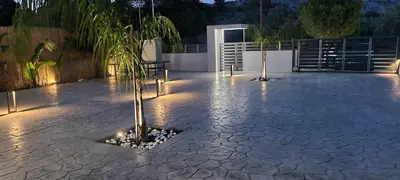 a courtyard with a palm tree and lights at night at M&B Luxury Villa in Haraki