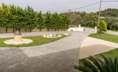 a driveway with a statue in the middle of a yard at Villa Nostra- Cars Included in Soroni