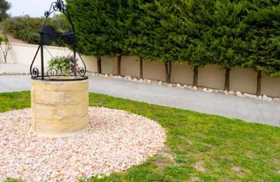 a bird feeder with flowers in it in the grass at Villa Nostra- Cars Included in Soroni