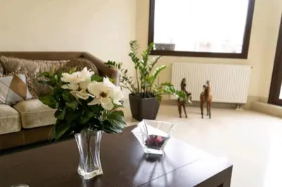 a living room with a vase of flowers on a table at Villa Nostra- Cars Included in Soroni