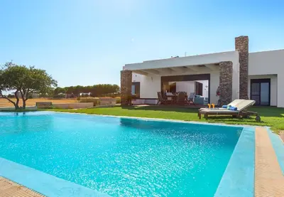 a swimming pool in front of a house at Cristelia seafront & pool villa in Lachania