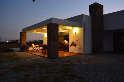 a small house with a patio at night at Cristelia seafront & pool villa in Lachania