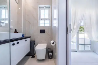 a bathroom with a toilet and a sink and a window at Katris Luxury Homes #1 in Triánta