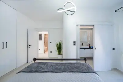 a white bedroom with a bed and a ceiling fan at Katris Luxury Homes #1 in Triánta
