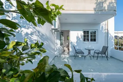 a patio with two chairs and a table on a house at Katris Luxury Homes #1 in Triánta