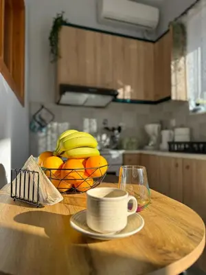 a table with a bowl of oranges and a bowl of bananas at The Sunlit Retreat in Kremasti