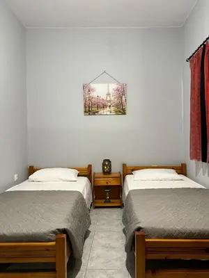 a bedroom with two beds and a picture on the wall at The Sunlit Retreat in Kremasti