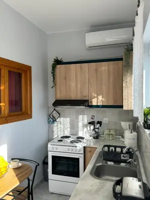 a kitchen with a stove and a sink at The Sunlit Retreat in Kremasti