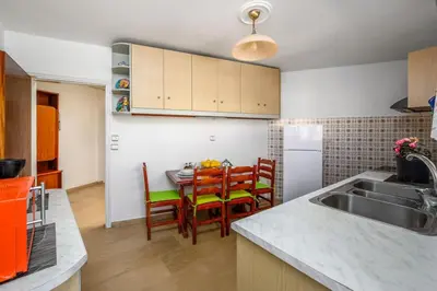 a kitchen with a sink and a table with chairs at Anerades city center apartment in Rhodes Town