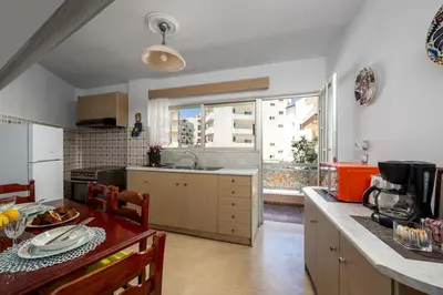 a kitchen with a table and a large window at Anerades city center apartment in Rhodes Town