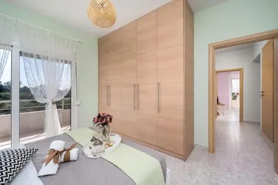 a bedroom with a large bed and a large window at Sunset villa Theologos in Theologos