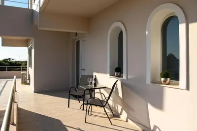 a patio with a table and chairs on a balcony at Sunset villa Theologos in Theologos