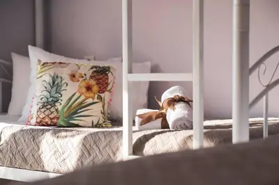a stuffed animal sitting on top of a bed at Sunset villa Theologos in Theologos