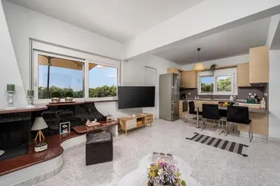 a living room with a kitchen and a dining room at Sunset villa Theologos in Theologos