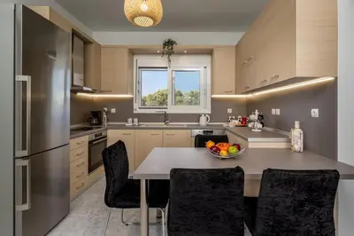a kitchen with a table with a bowl of fruit on it at Sunset villa Theologos in Theologos