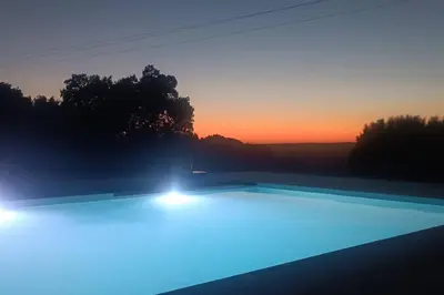 a swimming pool with blue lights in front of a sunset at Imagio 22 in Sálakos