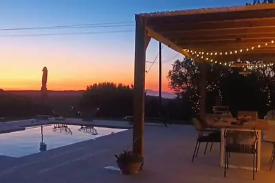 a patio with a table and chairs and a sunset at Imagio 22 in Sálakos