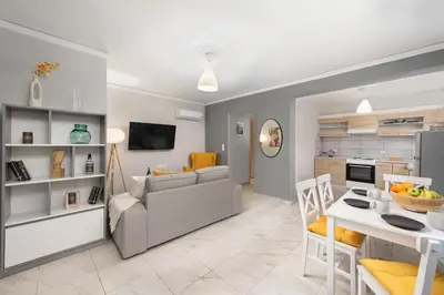 a living room and kitchen with a couch and a table at Marasi Apartment - Islander's Home Collection in Rhodes Town