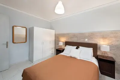 a bedroom with a large bed and a mirror at Marasi Apartment - Islander's Home Collection in Rhodes Town