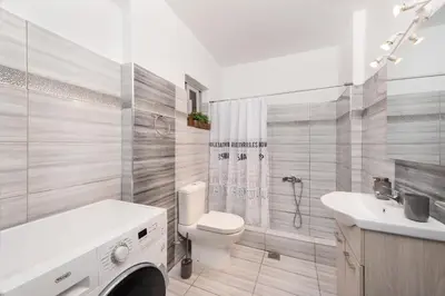 a white bathroom with a toilet and a sink at Marasi Apartment - Islander's Home Collection in Rhodes Town