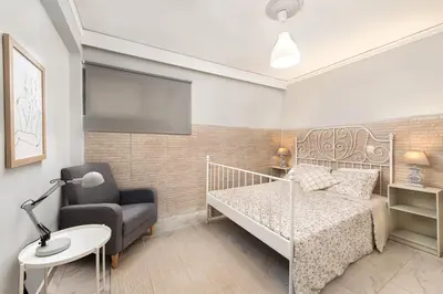 a small bedroom with a bed and a chair at Marasi Apartment - Islander's Home Collection in Rhodes Town
