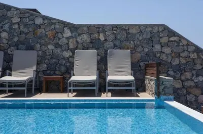 a group of chairs sitting next to a swimming pool at Pefkos Heights Private Pool Villa in Pefki Rhodes