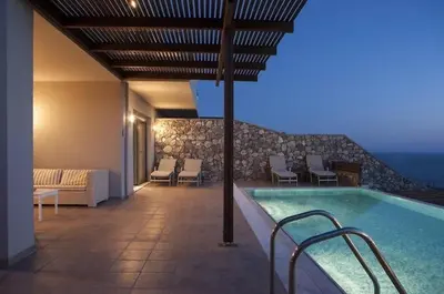 a swimming pool in a building with chairs at Pefkos Heights Private Pool Villa in Pefki Rhodes