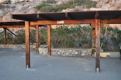 a wooden pavilion in front of a stone wall at Pefkos Heights Private Pool Villa in Pefki Rhodes