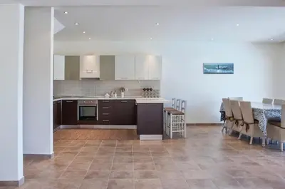 a kitchen and dining room with a table and chairs at Pefkos Heights Private Pool Villa in Pefki Rhodes