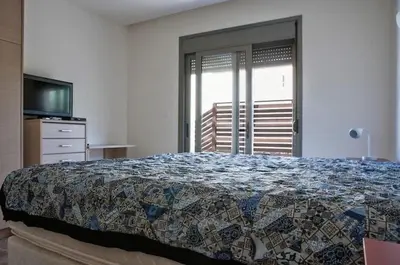 a bedroom with a bed and a television and a window at Pefkos Heights Private Pool Villa in Pefki Rhodes