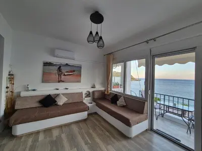 a living room with a couch and a view of the ocean at Anastasia Beach House Haraki in Rhodes Town