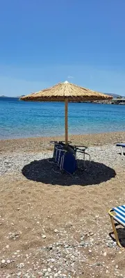 a picnic table and an umbrella on a beach at Anastasia Beach House Haraki in Rhodes Town