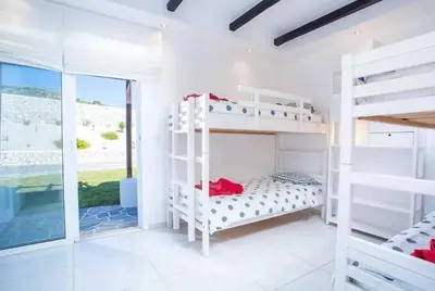 a bedroom with two bunk beds and a window at Villa Franky Ladikoheizbarer Pool in Faliraki