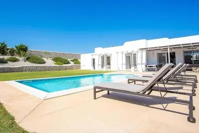 a villa with a swimming pool and two lounge chairs at Villa Franky Ladikoheizbarer Pool in Faliraki