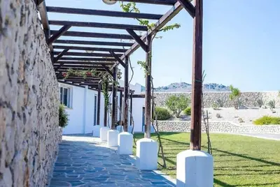 a stone walkway with a wooden pergola at Villa Franky Ladikoheizbarer Pool in Faliraki